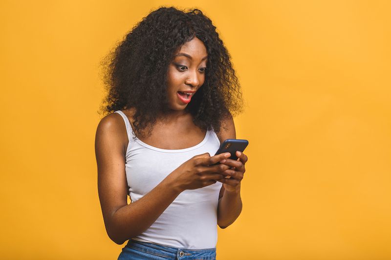 Young woman texting looking excited