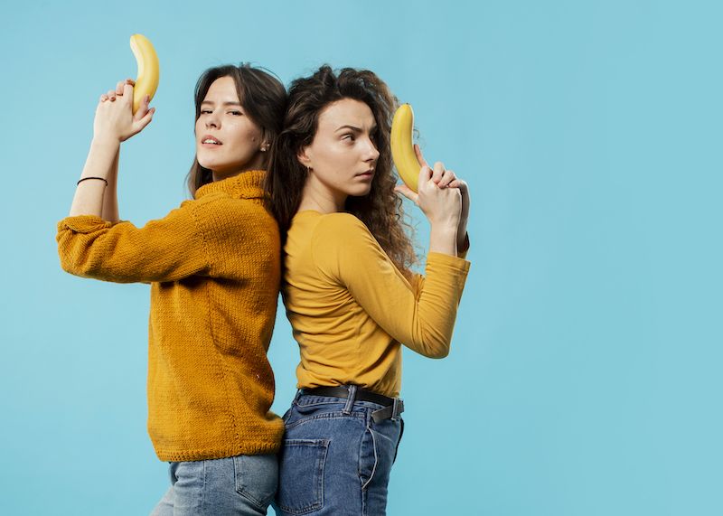 Young women holding bananas