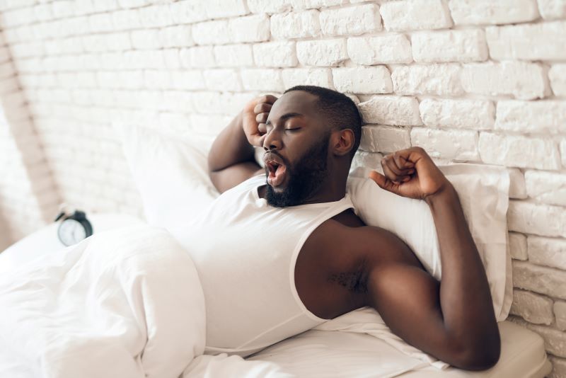 Homme se réveillant le matin et s'étirant