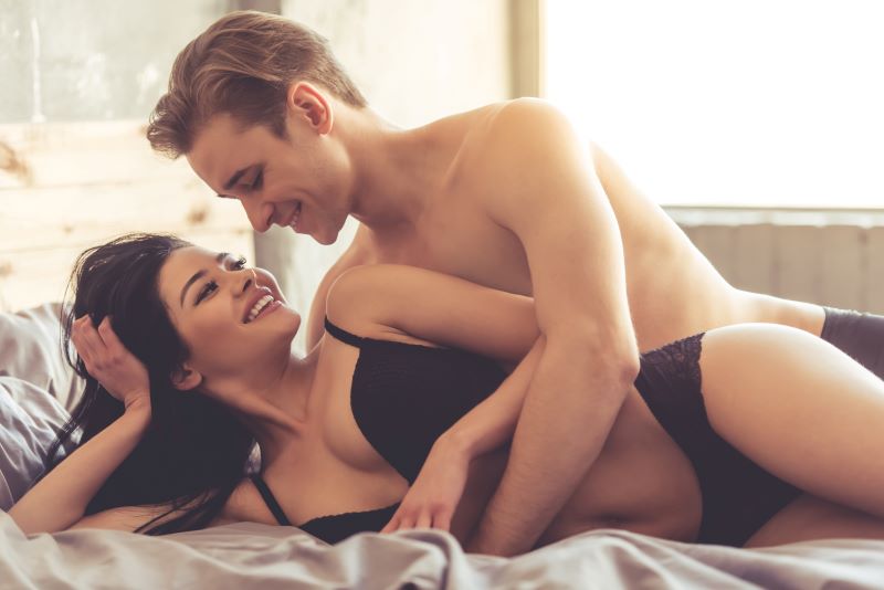 Sensual couple smiling in bed