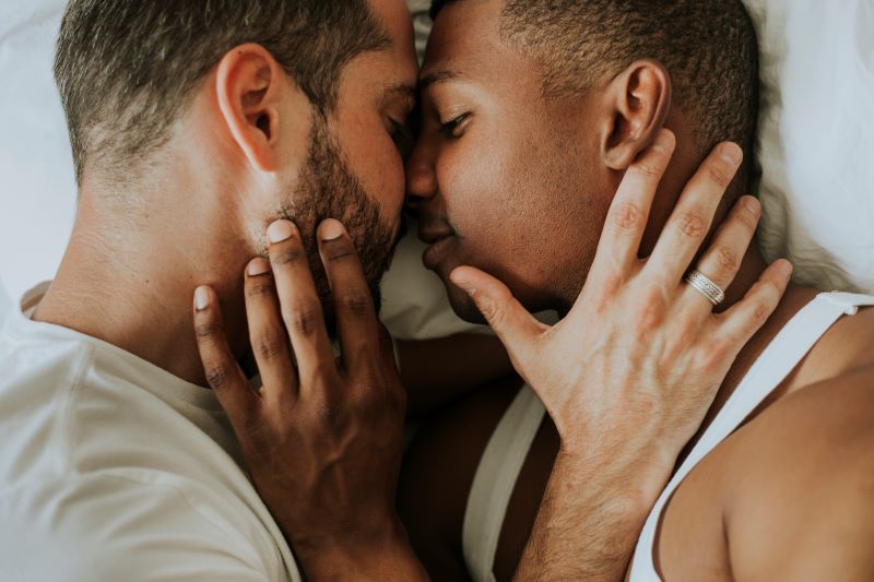 Sensual couple in bed touching faces