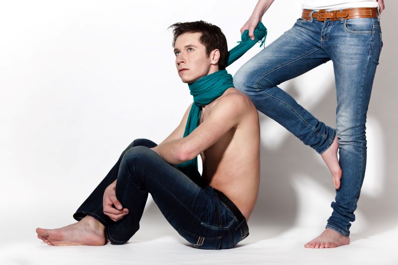 Woman holding scarf around man's neck