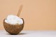 Une demi-noix de coco avec de l'huile de coco à l'intérieur