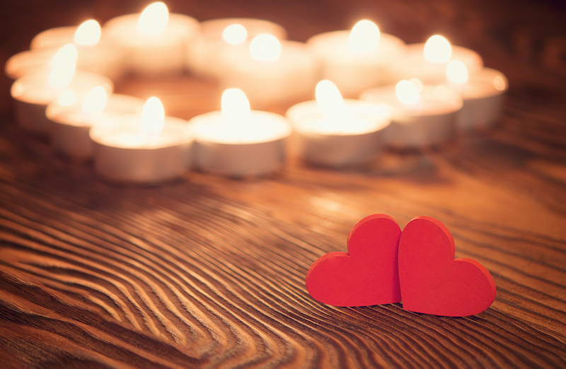 Deux coeurs d'amour avec des bougies en forme de coeur derrière eux