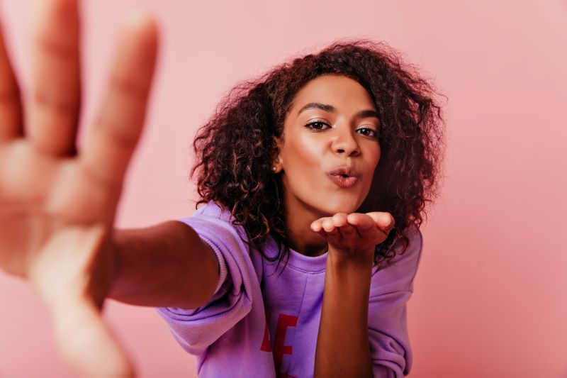 Woman blowing a kissing and taking selfie