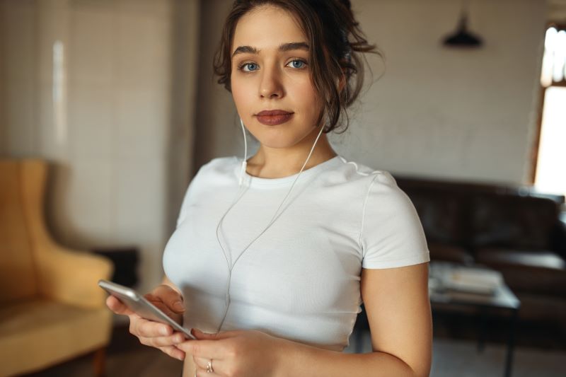 Woman holding her phone at home