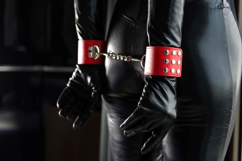 Woman in leather outfit in red handcuffs
