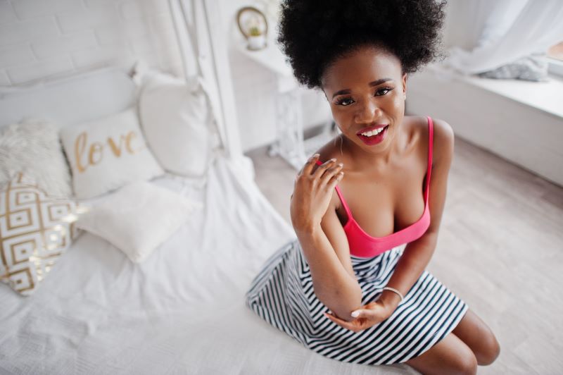 Woman sitting on bed posing