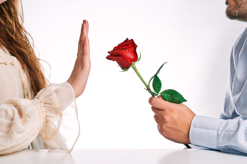 Woman rejecting red rose from her partner