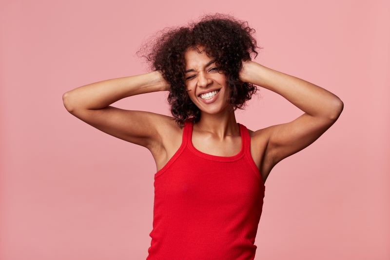 Femme souriante avec les mains dans les cheveux