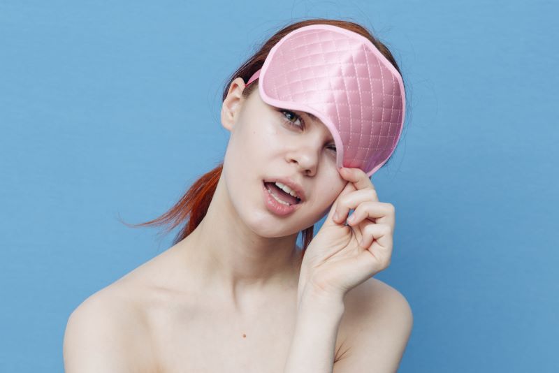 Woman holding eye mask on her head