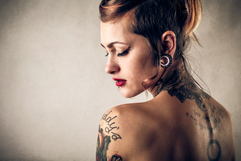 Woman with tattoos and piercings posing