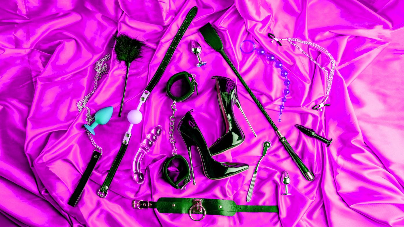 Équipement et jouets de jeux BDSM pour adultes sur une feuille rose