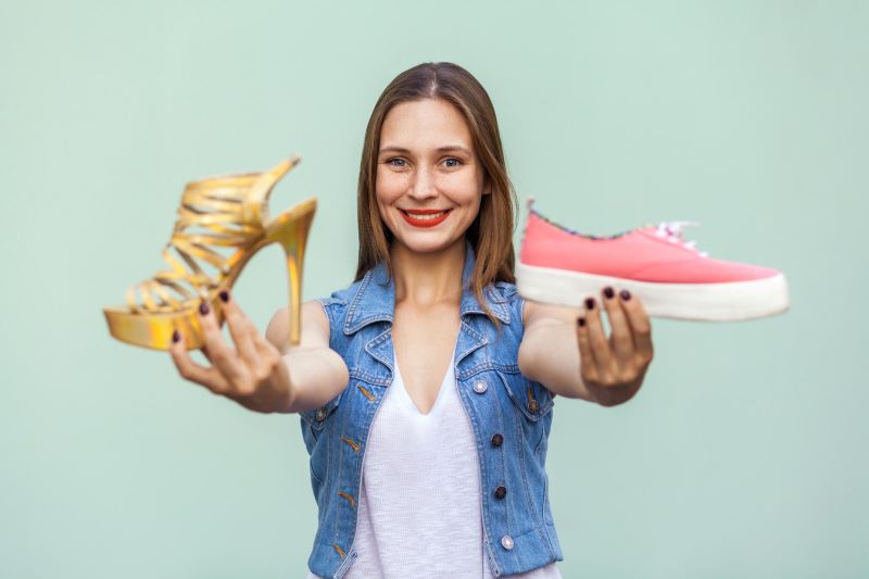woman holding smelly socks and worn shoes